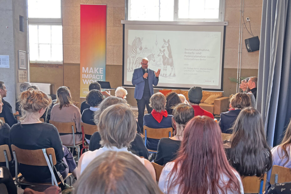 Plenum mit einer Person die mit Mikrofon spricht